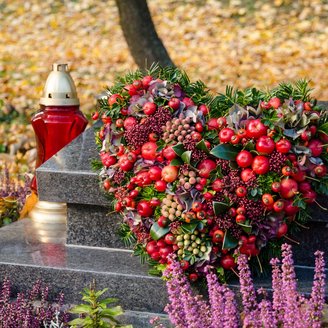 Ein winterliches Gesteck in Form eines Herzens am Grab.